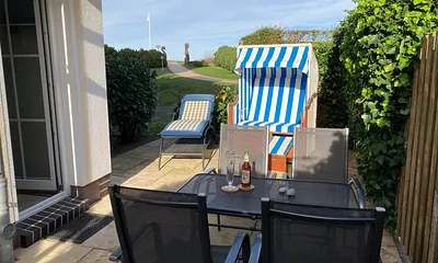 Terrasse mit Komfort-Strandkorb und Sonnenliege