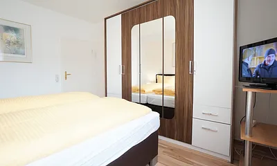 Schlafzimmer mit Doppelbett und Flachbildfernseher