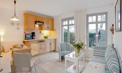  Wohn-, Ess- und Kochbereich mit angrenzender Terrasse mit Strandkorb