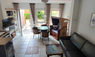 Wohnzimmer mit Kamin und Strandkorb mit Eßplatz für 4 Personen. 