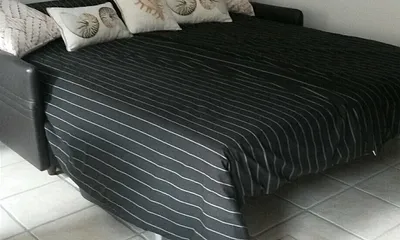 Schlafcouch mit Blick zum Kamin und Fernseher, mit Matratze und Bettkasten . 