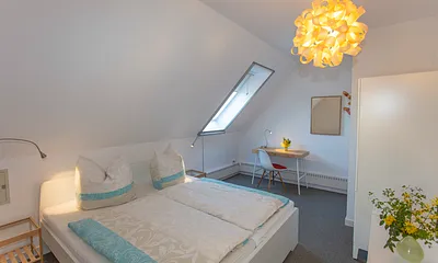 Schlazimmer 2 mit Doppelbett und Schreibtisch