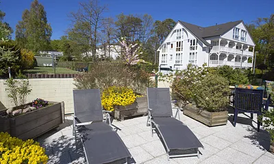 Terrasse mit Sonnenliegen und Gartenstühle
