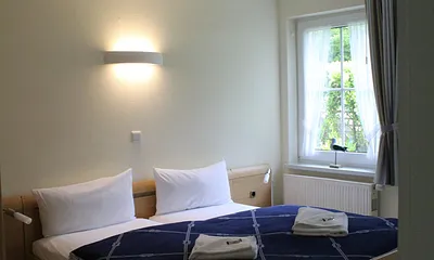Schlafzimmer mit Doppelbett und Zugang zum Duschbad mit WC.
