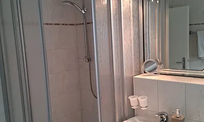 Badezimmer mit WC und Dusche und Fön