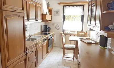 Separate, geräumige Küche mit Echtholz-Front, komplett ausgestattet