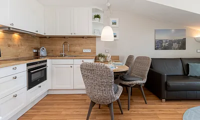 Wohn- und Essbereich, vollausgestattete Einbauküche mit Espressomaschine, Milchaufschäumer, Handrührgerät, Kombimikrowelle, 4-Sterne-Gefrierfach, hochwertiges Arbeitsgeschirr.