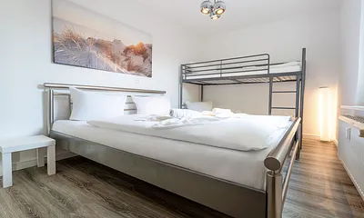 Schlafzimmer mit Doppelbett und Etagenbett