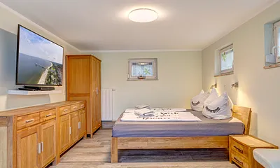 Schlafzimmer mit Doppelbett und TV