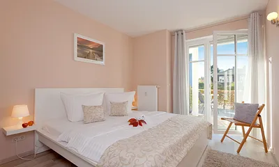 Schlafzimmer mit Doppelbett und angrenzender Terrasse