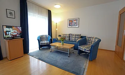 Wohnzimmer mit Flachbildfernseher und Schlafcouch
