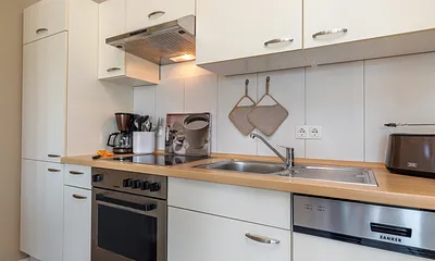 ... Cerankochfeld, Backofen und Kühlschrank mit Eisfach.