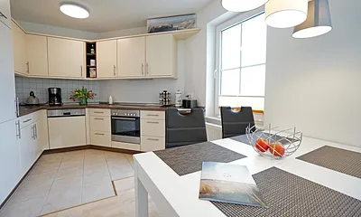 Wohnzimmer mit Esstisch und Küchenzeile