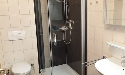 renoviertes Duschbad mit tiefem Einstieg in die Dusch und Fenster