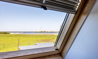 Aus dem Fenster sehen Sie die Weiden, den Bodden und die Wittower Fähre.