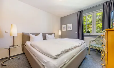 Das Schlafzimmer mit Doppelbett und Außenrolladen am Fenster ... 