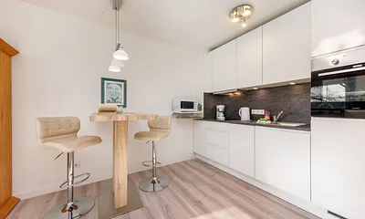 Die Küchenzeile ist ausgetattet mit Cerankochfeld, Backofen, Geschirrspüler, Toaster, Kaffee- und Wasserkocher sowie Kühlschrank mit Eisfach.