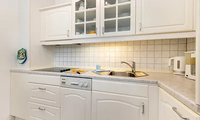 Die Küchenzeile ist ausgetattet mit Cerankochfeld, Geschirrspüler, Toaster, Kaffee- und Wasserkocher sowie Kühlschrank mit Eisfach.