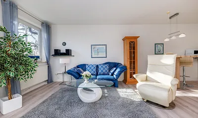 Das helle und freundlich möblierte Wohnzimmer.