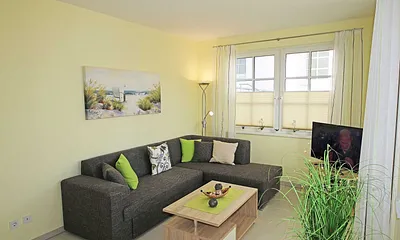 Wohnbereich mit vollwertiger Schlafcouch mit Ottomane (Aufbettung 3. Person, 1,25m x 2,00m), Couchtisch, Leselampe, Smart-TV, Blu Ray Player, Mini-Stereo-Anlage und Insektenschutzgitter