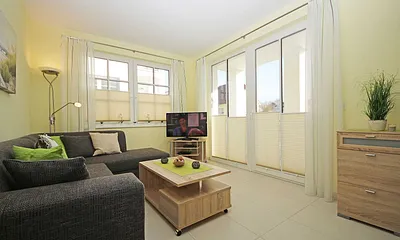 Wohnbereich mit vollwertiger Schlafcouch mit Ottomane (Aufbettung 3. Person, 1,25m x 2,00m), Couchtisch, Leselampe, Smart-TV, Blu Ray Player, Mini-Stereo-Anlage und Insektenschutzgitter