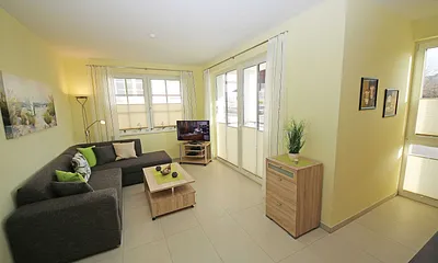 Wohnbereich mit vollwertiger Schlafcouch mit Ottomane (Aufbettung 3. Person, 1,25m x 2,00m), Couchtisch, Leselampe, Smart-TV, Blu Ray Player, Mini-Stereo-Anlage und Insektenschutzgitter