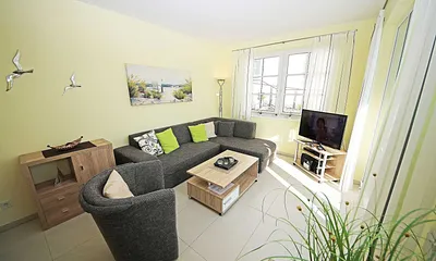 Wohnbereich mit vollwertiger Schlafcouch mit Ottomane (Aufbettung 3. Person, 1,25m x 2,00m), Couchtisch, Leselampe, Smart-TV, Blu Ray Player, Mini-Stereo-Anlage und Insektenschutzgitter