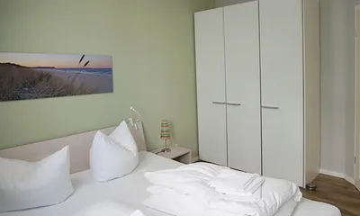 Schlafzimmer mit Doppelbett (1,80m x 2,00m), 2 Nachttischkonsolen, Flachbildschirm-TV-Gerät, Insektenschutzgitter und ein Kleiderschrank