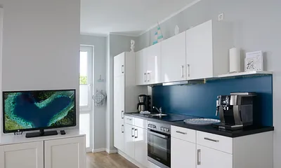 Einbauküche mit 4-Zonen-Cerankochfeld und Backofen, Kühlschrank mit 3*-Gefrierfach, Toaster, Wasserkocher, Geschirrspülmaschine, Kaffeemaschine mit Thermoskanne sowie einen Delongi Kaffeevollautomat  