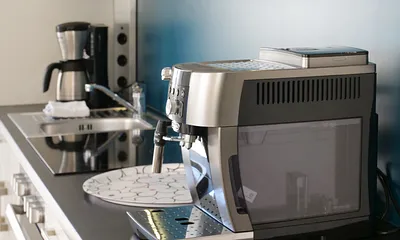 Einbauküche mit 4-Zonen-Cerankochfeld und Backofen, Kühlschrank mit 3*-Gefrierfach, Toaster, Wasserkocher, Geschirrspülmaschine, Kaffeemaschine mit Thermoskanne sowie einen Delongi Kaffeevollautomat  