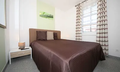 Schlafzimmer mit Boxspringbett (1,80 m x 2,00 m), Full HD Flachbildschirm, stillen Diener, zwei Nachtkonsolen, Kleiderschrankund Insektenschutzgitter