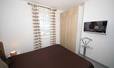 Schlafzimmer mit Boxspringbett (1,80 m x 2,00 m), Full HD Flachbildschirm, stillen Diener, zwei Nachtkonsolen, Kleiderschrankund Insektenschutzgitter