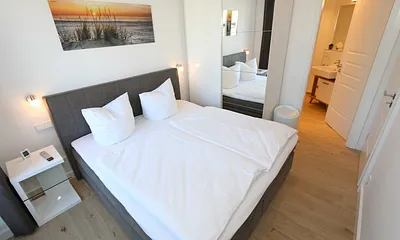 erstes Schlafzimmer mit Kleiderschrank und kleinem Bad
