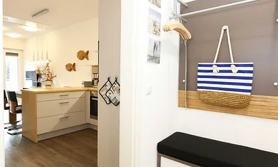 heller Flur mit Garderobe, Sitzgelegenheit und bodentiefem Spiegel