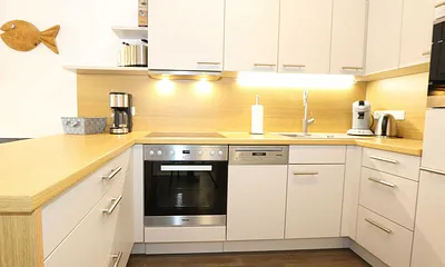 Küchenzeile mit Mikrowelle, Backofen, Induktionskochfeld, Geschirrspüler, Kaffeemaschine, Pad-Maschine (Senseo), Wasserkocher, Eierkocher, Toaster, Handmixer und Kühlschrank mit Gefrierfach 