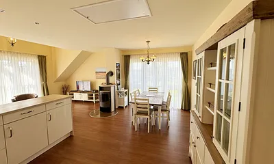 Wohn-/Esszimmer mit Massivmöbel im Landhausstil und bodentiefen Fenstern