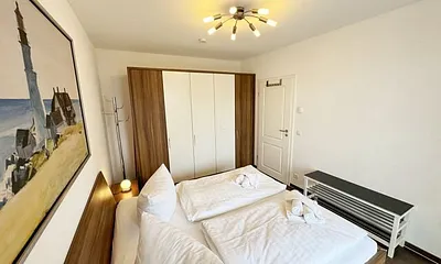 Schlafbereich mit Doppelbett (1,80 m x 2,00 m), Nachttischkonsolen und Kleiderschrank