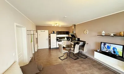 Wohnbereich mit Schlafsofa (Ausziehfunktion 1,30m x 2,00m für 2 Personen), kleiner Couchtisch, Leselampe, TV-Board mit Smart-TV, Receiver, DVD/Blu-Ray-Player und Ministereoanlage