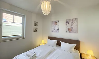 Schlafbereich mit Doppelbett (1,80 m x 2,00 m mit H2/H3 Matratzen) sowie verstellbare Lattenroste, Nachttischkonsolen und Kleiderschrank