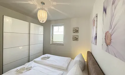 Schlafbereich mit Doppelbett (1,80 m x 2,00 m mit H2/H3 Matratzen) sowie verstellbare Lattenroste, Nachttischkonsolen und Kleiderschrank