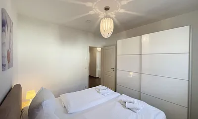 Schlafbereich mit Doppelbett (1,80 m x 2,00 m mit H2/H3 Matratzen) sowie verstellbare Lattenroste, Nachttischkonsolen und Kleiderschrank