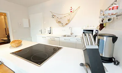 Küchenbereich mit Cerankochfeld, Backofen, Geschirrspüler, Kühlschrank, Kaffeemaschine, Mikrowelle, Wasserkocher, Mixer, Toaster und umfangreiche Küchenausstattung