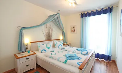 Schlafzimmer mit Doppelbett (1,80 m x 2,00 m), 7 Zonen-Kaltschaummatratzen, verstellbaren Lattenrosten, Nachttischablagen, Insektenschutzgitter, Verdunkelungsrollo und geräumiger Kleiderschrank