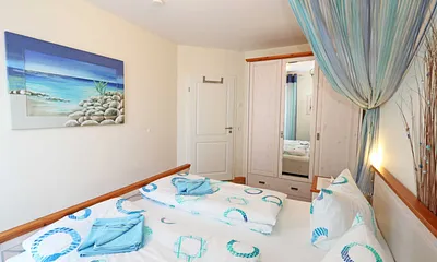 Schlafzimmer mit Doppelbett (1,80 m x 2,00 m), 7 Zonen-Kaltschaummatratzen, verstellbaren Lattenrosten, Nachttischablagen, Insektenschutzgitter, Verdunkelungsrollo und geräumiger Kleiderschrank