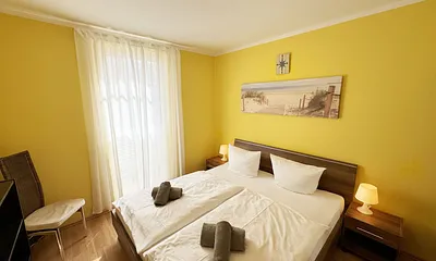 komfortables Schlafzimmer mit Doppelbett (1,80 m x 2,00 m), hochwertigen Matratzen, verstellbaren Lattenrosten, 2 Nachttischlampen, Flachbild-TV und Kleiderschrank