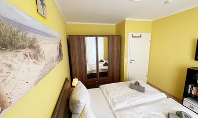 komfortables Schlafzimmer mit Doppelbett (1,80 m x 2,00 m), hochwertigen Matratzen, verstellbaren Lattenrosten, 2 Nachttischlampen, Flachbild-TV und Kleiderschrank