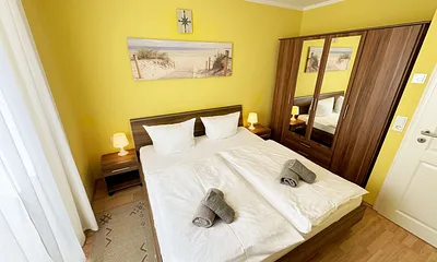 komfortables Schlafzimmer mit Doppelbett (1,80 m x 2,00 m), hochwertigen Matratzen, verstellbaren Lattenrosten, 2 Nachttischlampen, Flachbild-TV und Kleiderschrank