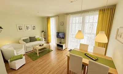  Wohnbereich mit einer Couch (Aufbettungsmöglichkeit für 3. Person – 1,20 m x 1,96 m), einen Sessel, Couchtisch, Leselampe, LED-TV und eine Mini-Stereoanlage mit CD und DVD-Player 