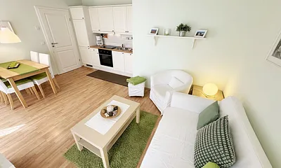 Wohnbereich mit einer Couch (Aufbettungsmöglichkeit für 3. Person – 1,20 m x 1,96 m), einen Sessel, Couchtisch, Leselampe, LED-TV und eine Mini-Stereoanlage mit CD und DVD-Player 