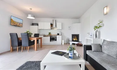 Wohnbereich mit offener Küche und Kamin